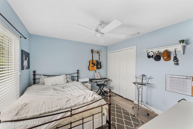 bedroom featuring a closet, ceiling fan, baseboards, and wood finished floors