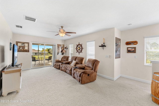 living room featuring visible vents, ceiling fan, light carpet, and baseboards