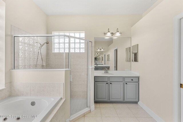 bathroom with baseboards, tile patterned floors, a garden tub, vanity, and a shower stall