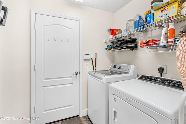 laundry room with a textured ceiling, laundry area, wood finished floors, and washing machine and clothes dryer