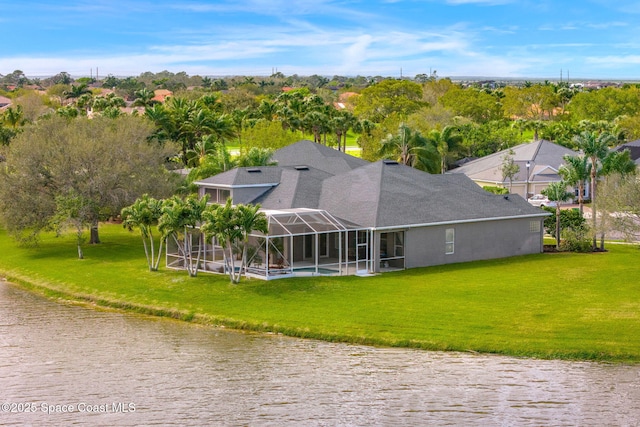 rear view of property with glass enclosure, a yard, and a water view