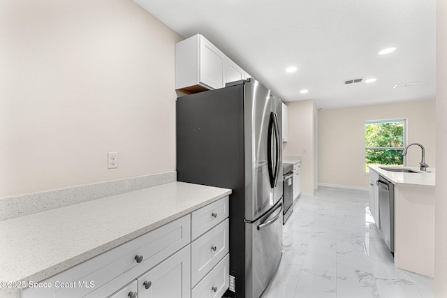 2100 Cogan Dr SE, Palm Bay, FL 32909 - kitchen featuring baseboards, appliances with stainless steel finishes, marble finish floor, white cabinetry, and a sink