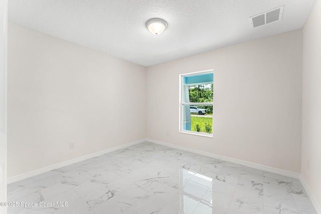 2100 Cogan Dr SE, Palm Bay, FL 32909 - unfurnished room featuring baseboards, visible vents, marble finish floor, and a textured ceiling