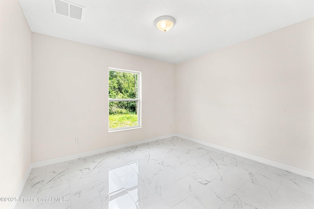 2100 Cogan Dr SE, Palm Bay, FL 32909 - spare room with a textured ceiling, visible vents, marble finish floor, and baseboards