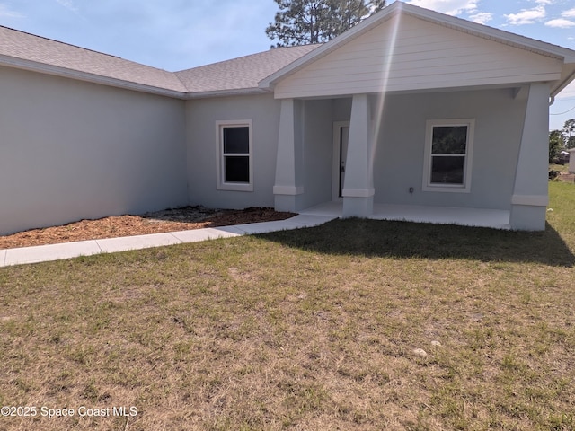 2100 Cogan Dr SE, Palm Bay, FL 32909 - view of front facade with a front yard, roof with shingles, and stucco siding