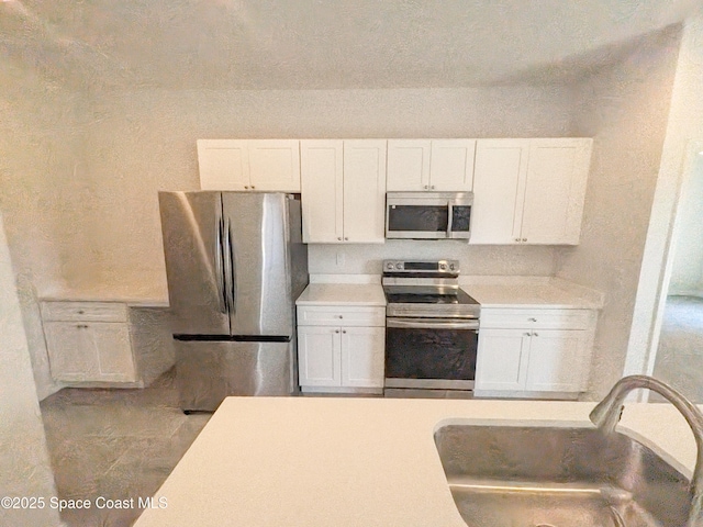 2100 Cogan Dr SE, Palm Bay, FL 32909 - kitchen featuring white cabinets, stainless steel appliances, light countertops, and a sink