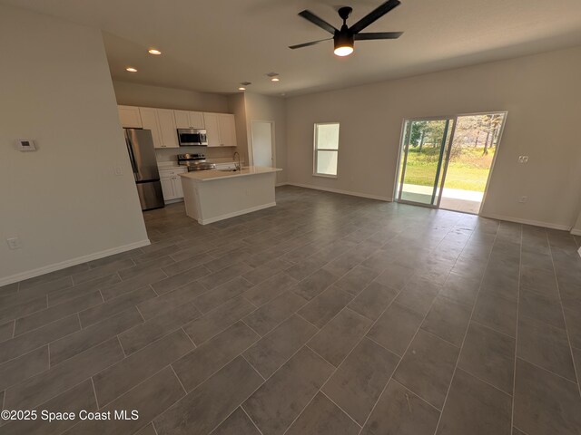 2100 Cogan Dr SE, Palm Bay, FL 32909 - unfurnished living room featuring a sink, baseboards, ceiling fan, and recessed lighting