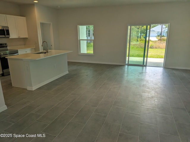 2100 Cogan Dr SE, Palm Bay, FL 32909 - kitchen with baseboards, a sink, light countertops, white cabinets, and appliances with stainless steel finishes