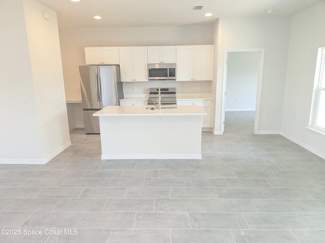 2100 Cogan Dr SE, Palm Bay, FL 32909 - kitchen featuring visible vents, light countertops, stainless steel appliances, white cabinetry, and a kitchen island with sink