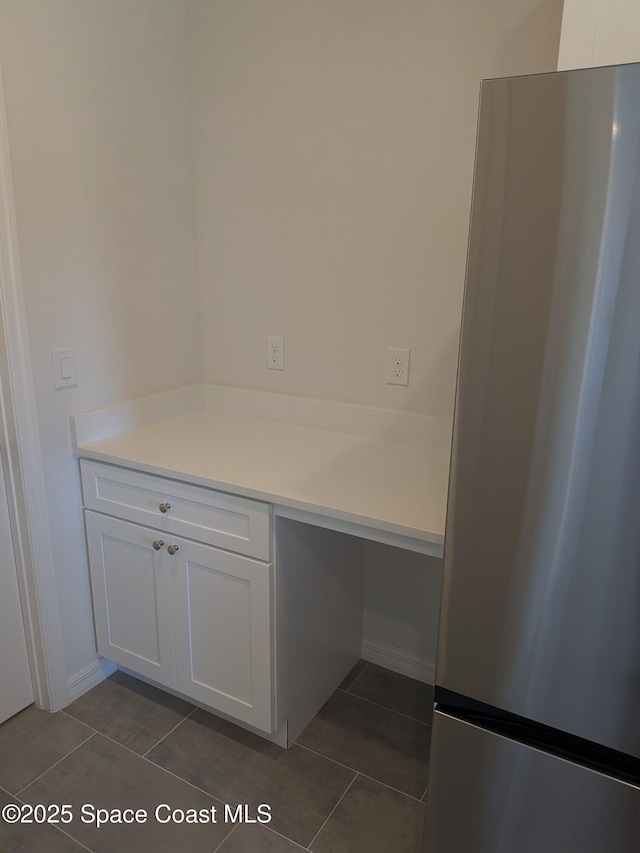 2100 Cogan Dr SE, Palm Bay, FL 32909 - kitchen with white cabinetry, dark tile patterned floors, and freestanding refrigerator