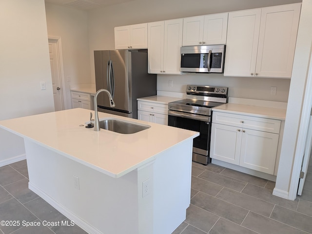 2100 Cogan Dr SE, Palm Bay, FL 32909 - kitchen featuring an island with sink, a sink, white cabinetry, stainless steel appliances, and tile patterned flooring