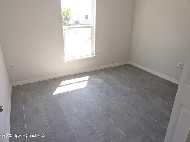 2100 Cogan Dr SE, Palm Bay, FL 32909 - empty room featuring baseboards and dark tile patterned flooring