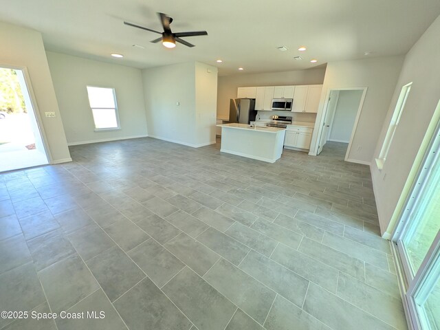2100 Cogan Dr SE, Palm Bay, FL 32909 - kitchen with a kitchen island with sink, open floor plan, recessed lighting, appliances with stainless steel finishes, and white cabinets