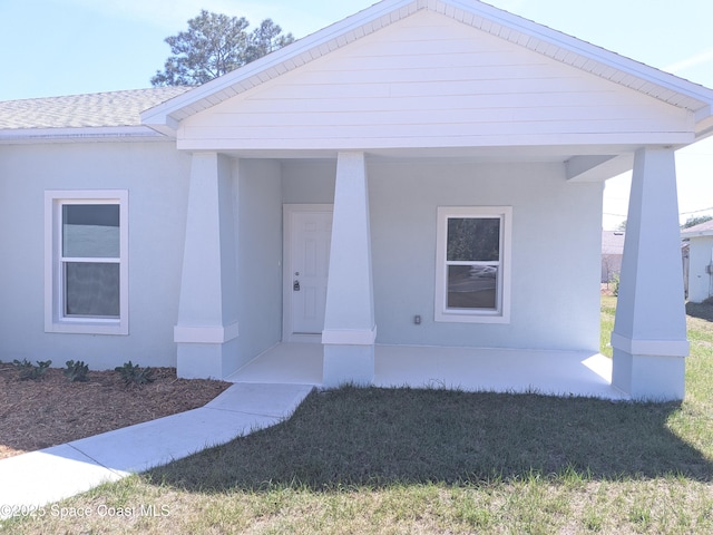 2100 Cogan Dr SE, Palm Bay, FL 32909 - view of exterior entry featuring stucco siding, covered porch, and a shingled roof