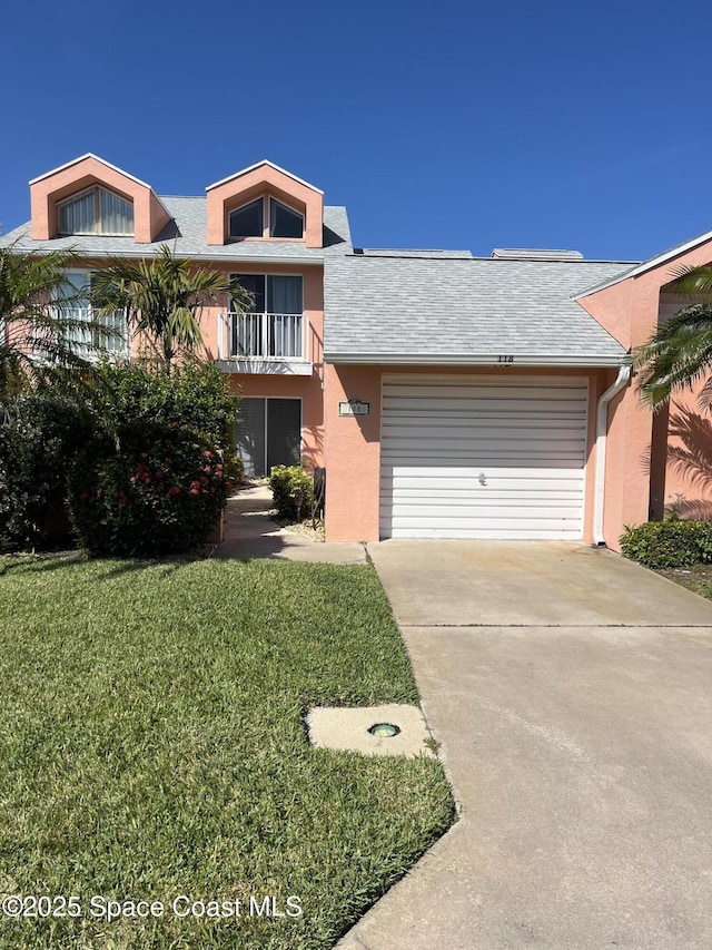 view of front of property with a garage, concrete driveway, a front lawn, and stucco siding