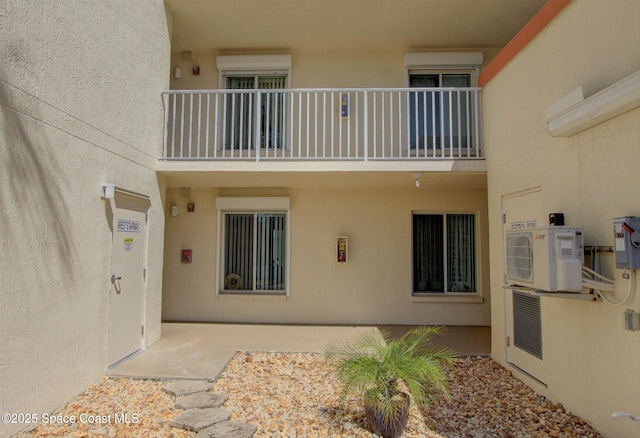 exterior space featuring ac unit, a balcony, and stucco siding