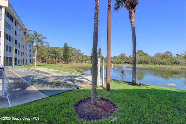 view of yard with a water view and shuffleboard