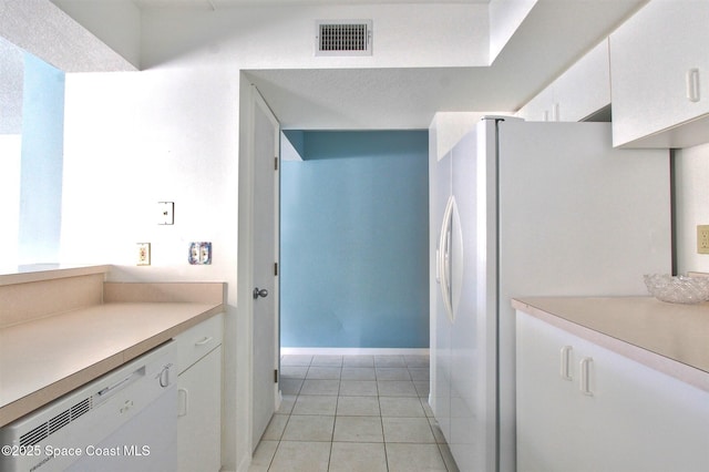 kitchen with white refrigerator with ice dispenser, light countertops, visible vents, white cabinetry, and dishwasher