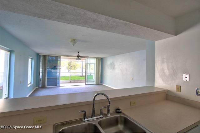 kitchen featuring open floor plan, a sink, and a ceiling fan