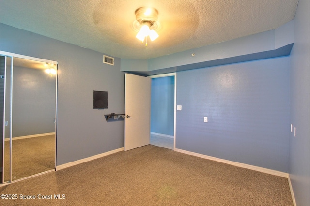 unfurnished bedroom with carpet floors, visible vents, and a textured ceiling