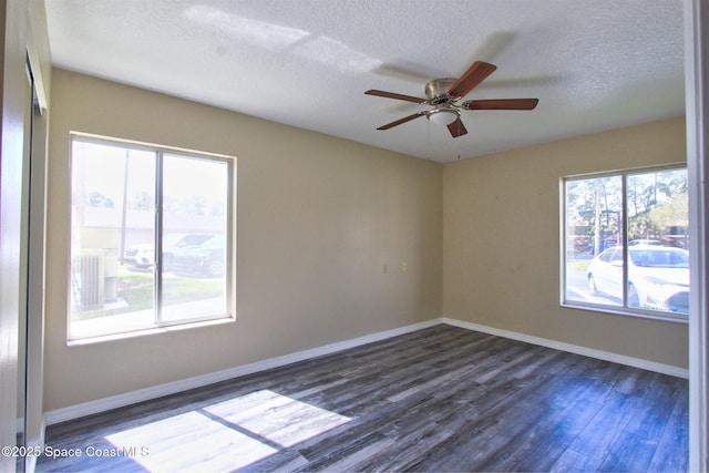 unfurnished room with dark wood-type flooring, plenty of natural light, and baseboards