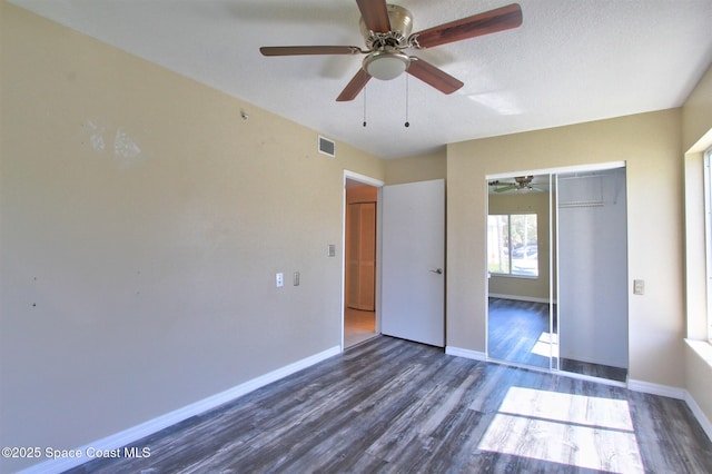 unfurnished bedroom with baseboards, visible vents, a ceiling fan, wood finished floors, and a closet