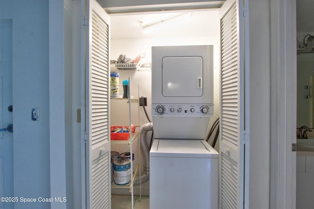 clothes washing area featuring laundry area and stacked washer / dryer