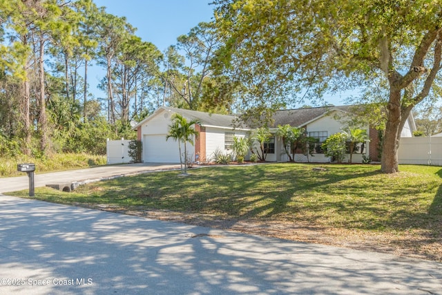 ranch-style house featuring an attached garage, fence, a front lawn, and concrete driveway