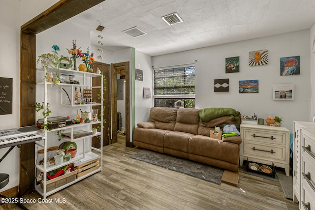 living area featuring visible vents, a textured ceiling, and wood finished floors