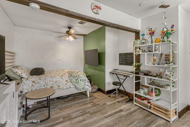 bedroom with visible vents, baseboards, and wood finished floors