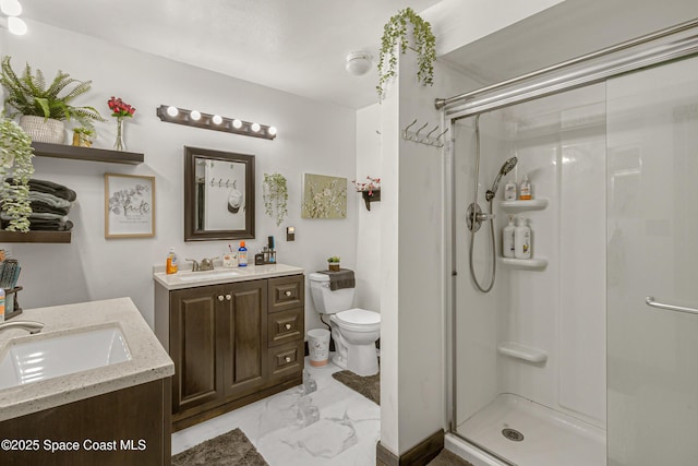 bathroom with toilet, marble finish floor, a stall shower, and vanity