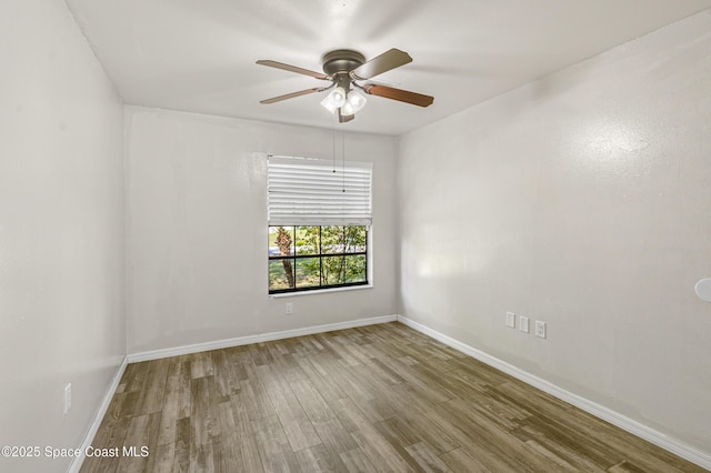 empty room with ceiling fan, baseboards, and wood finished floors