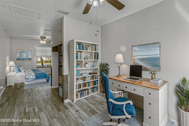 office featuring a textured wall, wood finished floors, visible vents, and attic access