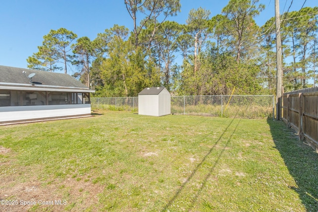 view of yard featuring an outbuilding, a sunroom, a fenced backyard, and a shed