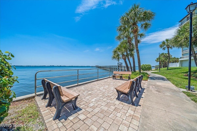 view of property's community featuring a lawn and a water view