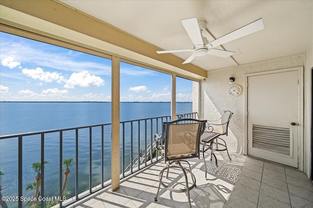 balcony featuring a water view and ceiling fan