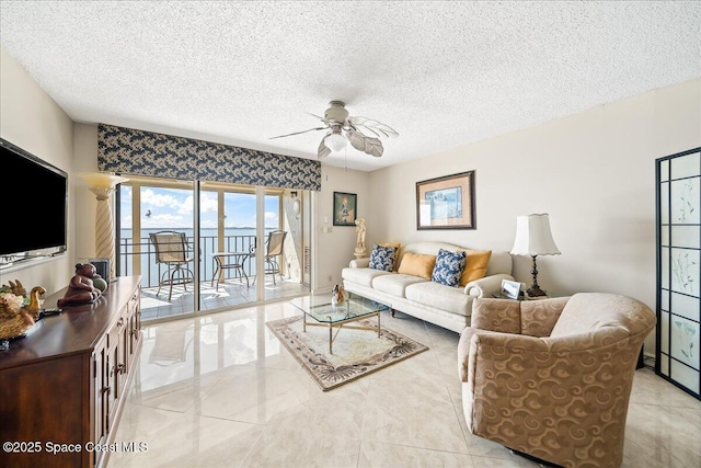 living room featuring ceiling fan and a textured ceiling