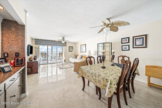 dining space featuring a ceiling fan, a textured ceiling, and baseboards