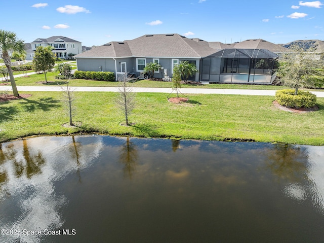 exterior space with a lanai, a water view, and a yard