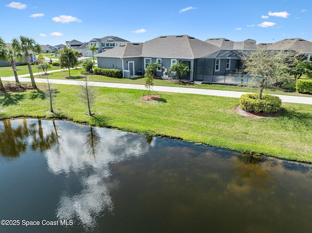 view of home's community with driveway, a water view, and a lawn