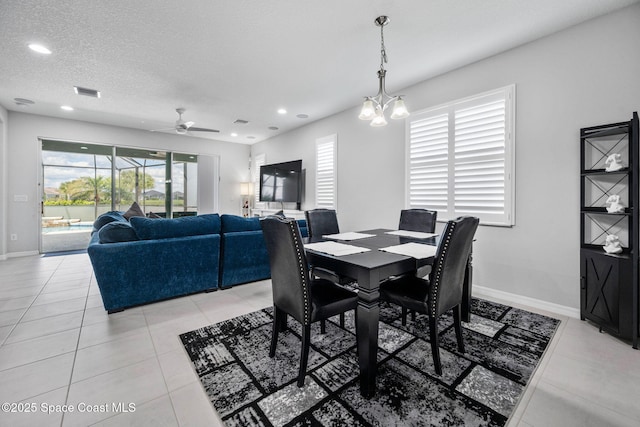 dining area with light tile patterned floors, a textured ceiling, visible vents, and baseboards