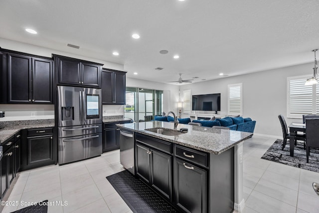 kitchen with stainless steel appliances, a sink, and dark cabinets