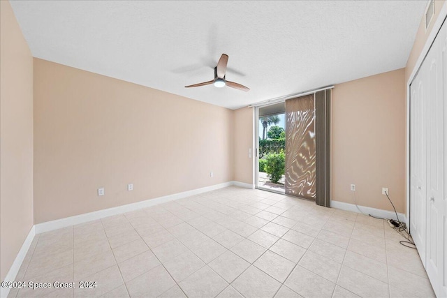 spare room with a ceiling fan, a textured ceiling, and baseboards