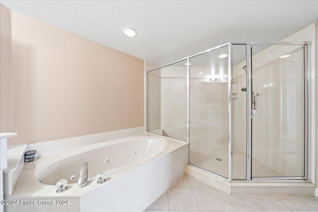 bathroom featuring a tub with jets, tile patterned flooring, and a shower stall