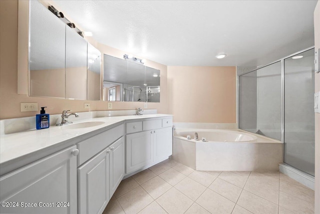 full bathroom featuring double vanity, a garden tub, tile patterned flooring, a shower stall, and a sink