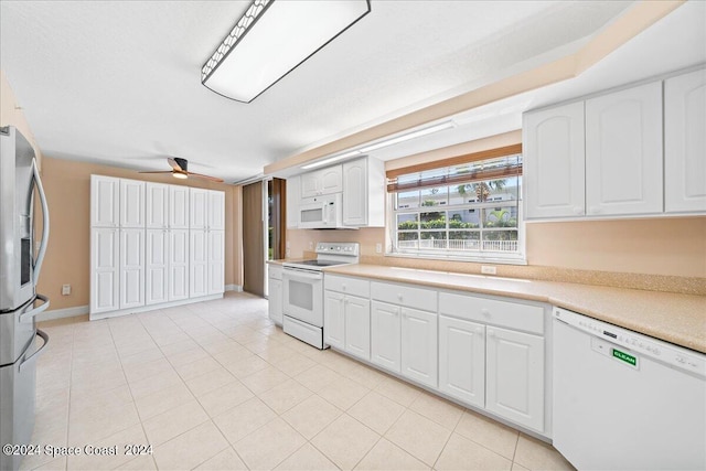 kitchen featuring white appliances, light tile patterned floors, baseboards, light countertops, and white cabinetry