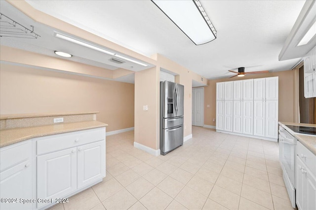 kitchen featuring stainless steel fridge, a ceiling fan, electric stove, light countertops, and white cabinetry