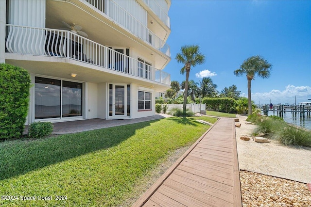 view of community with a water view, a patio area, and a yard