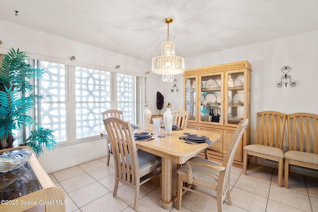 dining area with light tile patterned flooring and an inviting chandelier