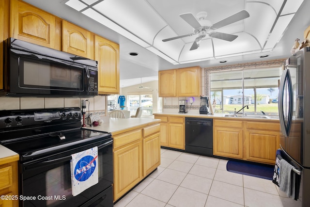 kitchen with a sink, black appliances, a raised ceiling, and light countertops